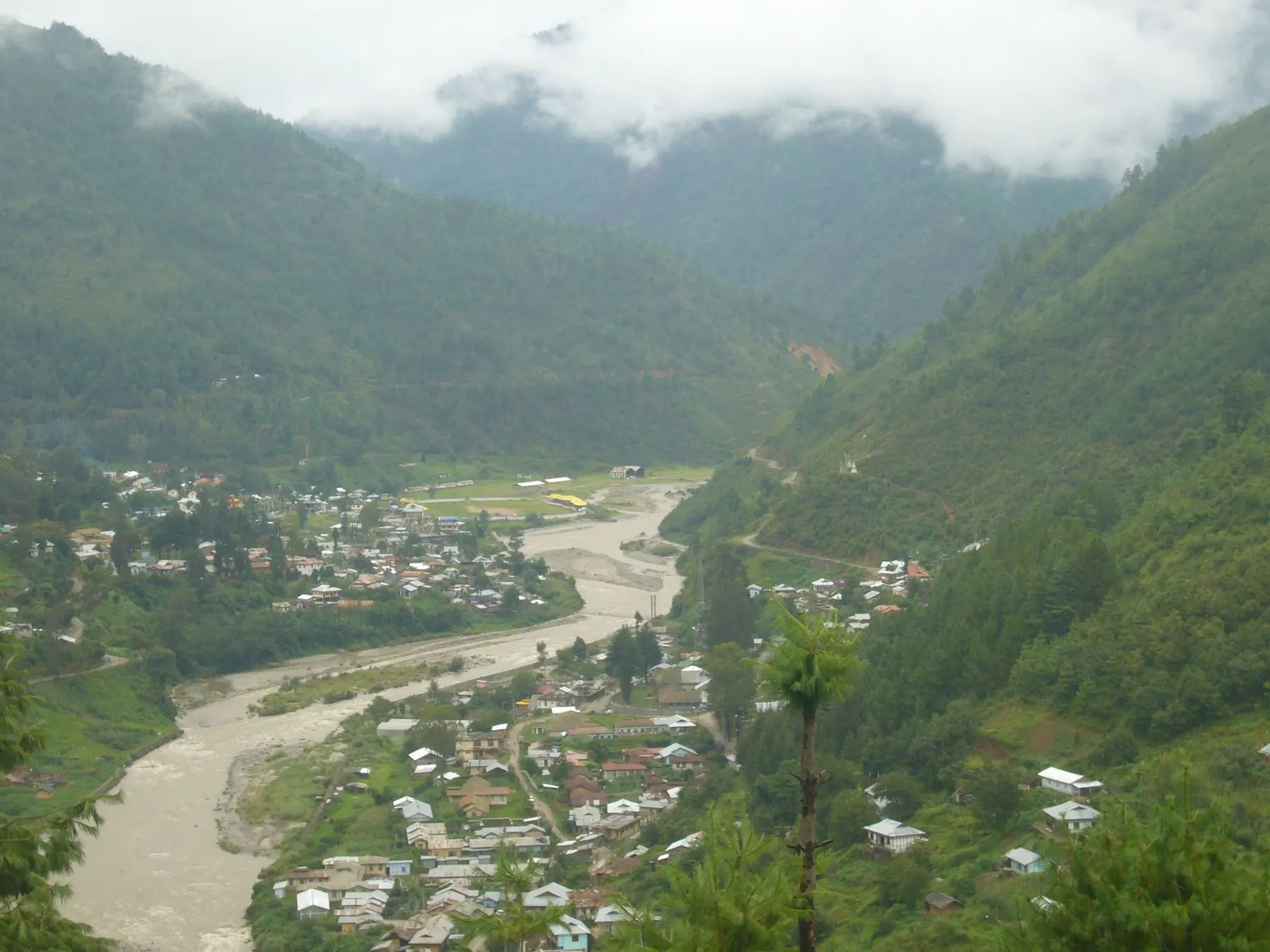 Dirang town along the river under misty hills