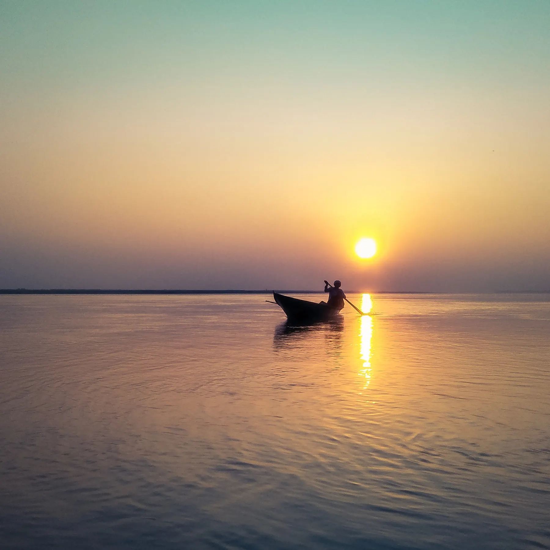 Fisherman on a boat at sunset on the Brahmaputra